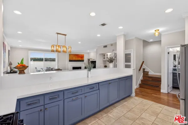 a open kitchen with stainless steel appliances kitchen island granite countertop a refrigerator and a view of living room