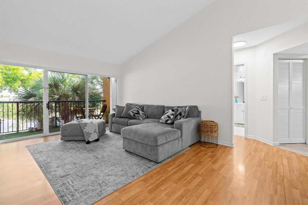 8851 Wiles Road, Unit 305 Coral Springs, FL 33067 - Photo 2 of 17 a living room with furniture and a large window
