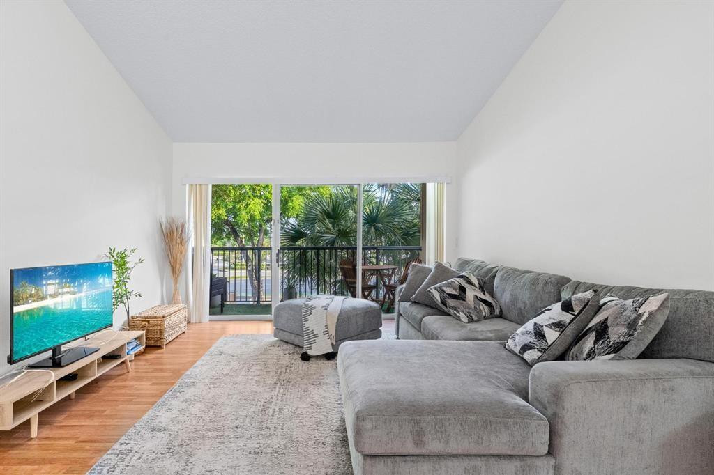 8851 Wiles Road, Unit 305 Coral Springs, FL 33067 - Photo 3 of 17 a living room with furniture and a flat screen tv