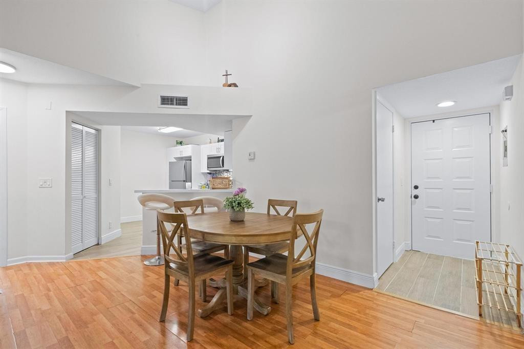 8851 Wiles Road, Unit 305 Coral Springs, FL 33067 - Photo 6 of 17 a view of a dining room with furniture and wooden floor