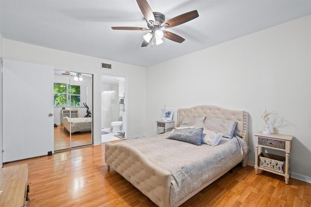 8851 Wiles Road, Unit 305 Coral Springs, FL 33067 - Photo 7 of 17 a bedroom with a bed and a chandelier