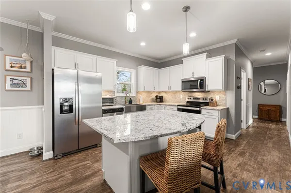 a kitchen with kitchen island a counter top space cabinets and stainless steel appliances