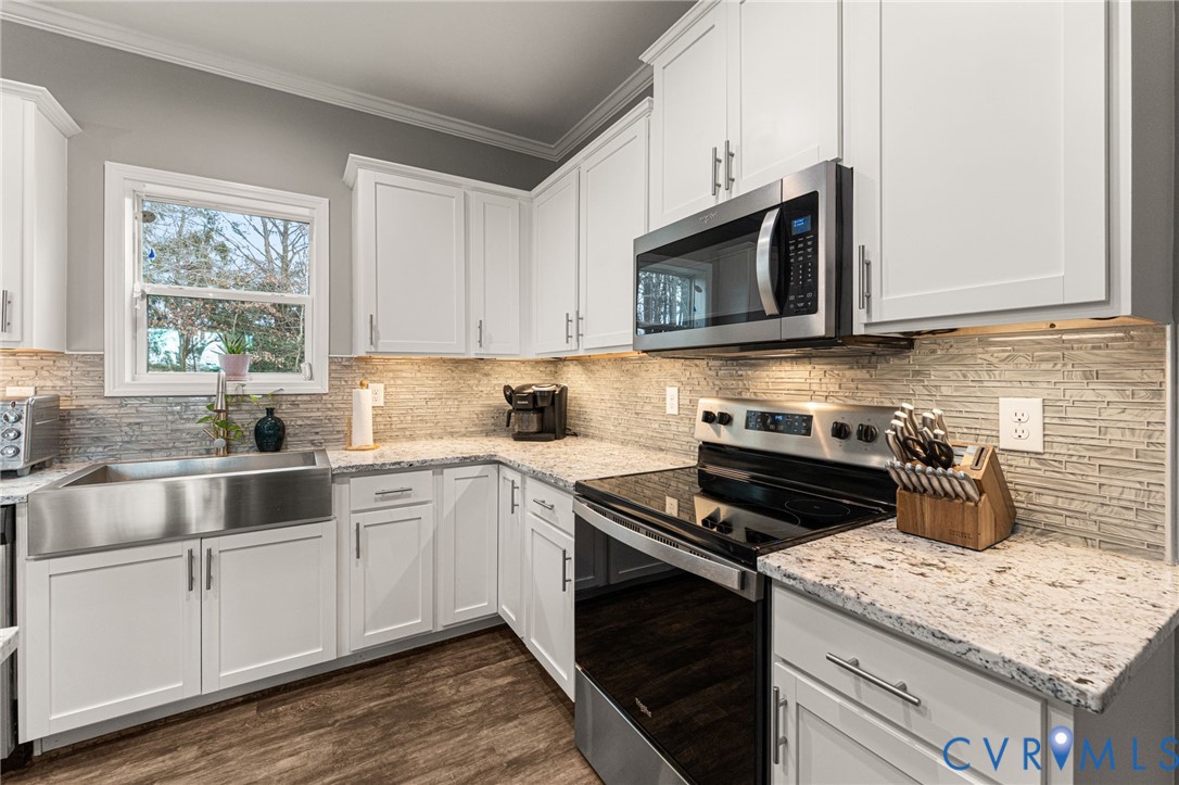 613 Doctors Point Road Lottsburg, VA 22511 - Photo 22 of 50 a kitchen with stainless steel appliances granite countertop a stove microwave and sink