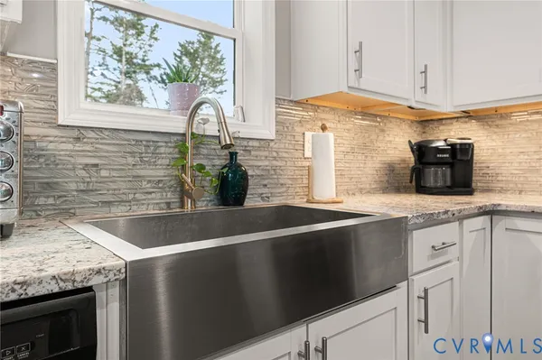 a kitchen with granite countertop a sink and a stove
