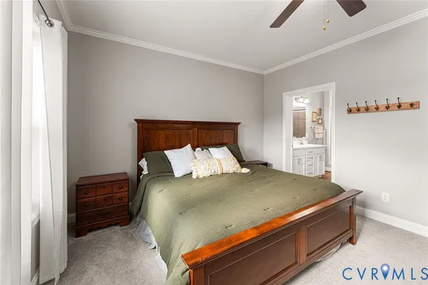 a bed sitting in a bedroom next to a window and a chandelier