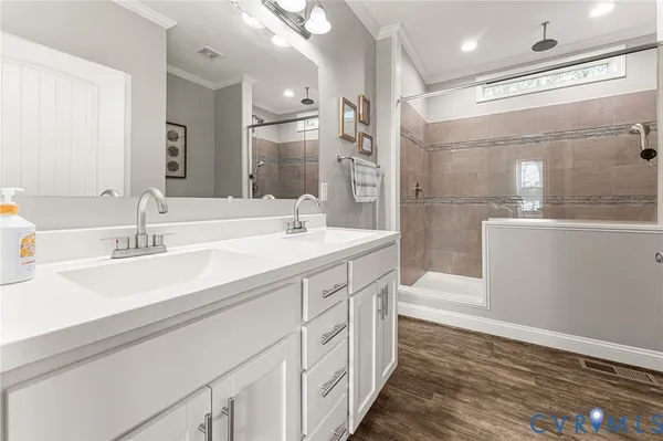 a spacious bathroom with a double vanity sink a mirror and a bathtub