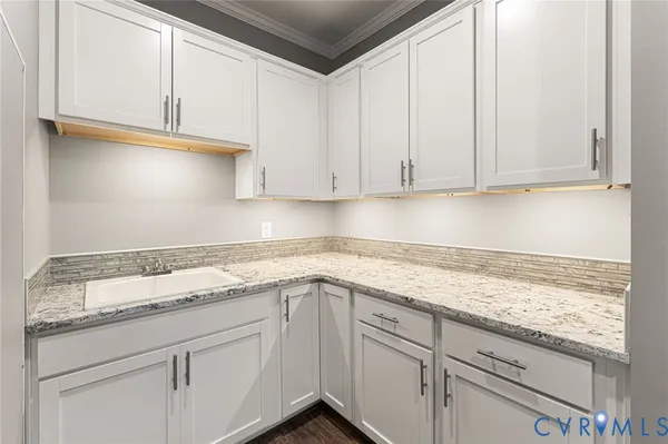 a kitchen with granite countertop white cabinets and sink
