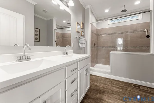 a bathroom with a double vanity sink mirror and shower