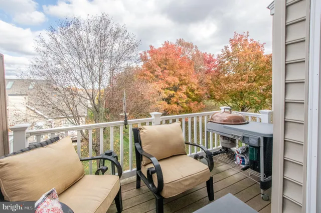 a balcony with wooden floor and outdoor seating
