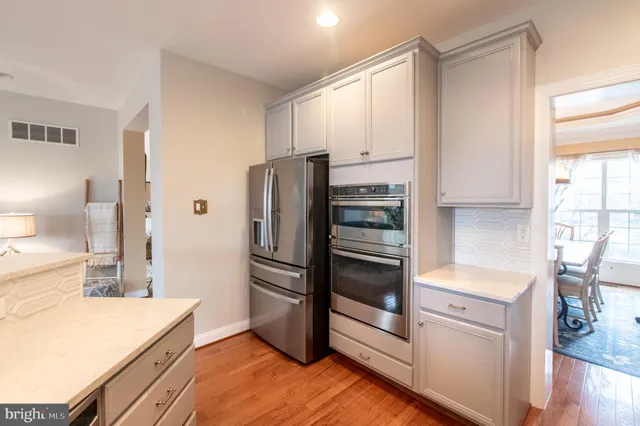 a kitchen with a refrigerator and a stove top oven