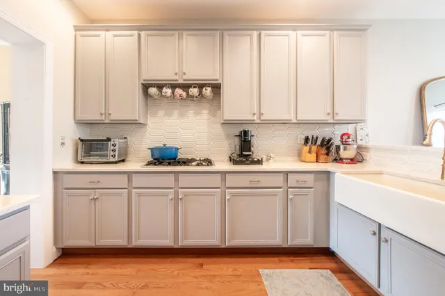 a kitchen with stainless steel appliances white cabinets and a window
