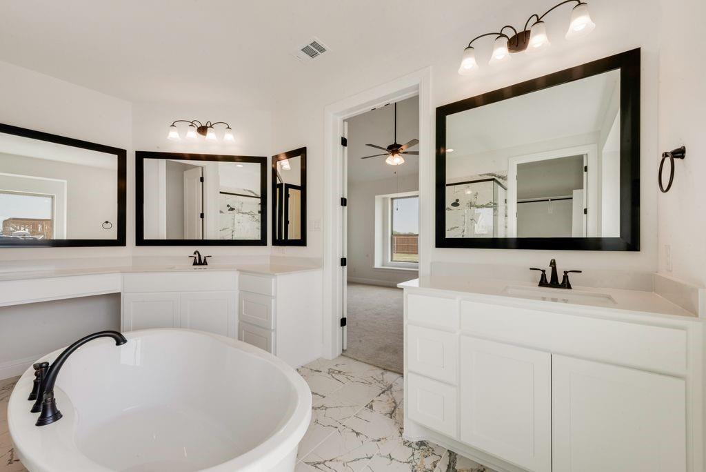 511 San Angelo Drive Forney, TX 75126 - Photo 18 of 34 a bathroom with a toilet a sink and mirror