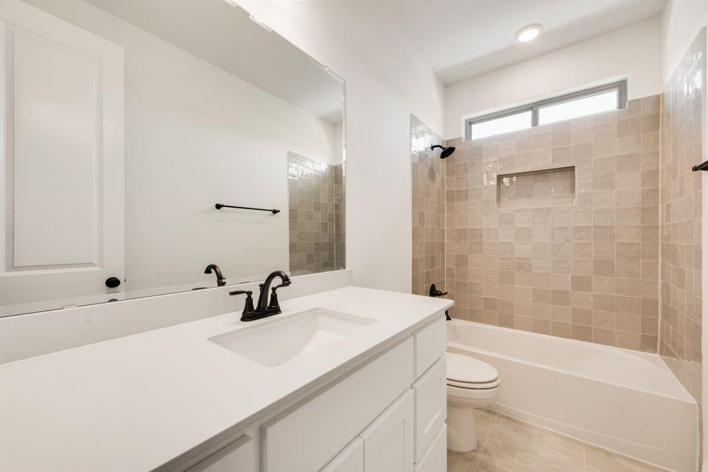 511 San Angelo Drive Forney, TX 75126 - Photo 20 of 34 a bathroom with a sink a toilet a mirror and shower