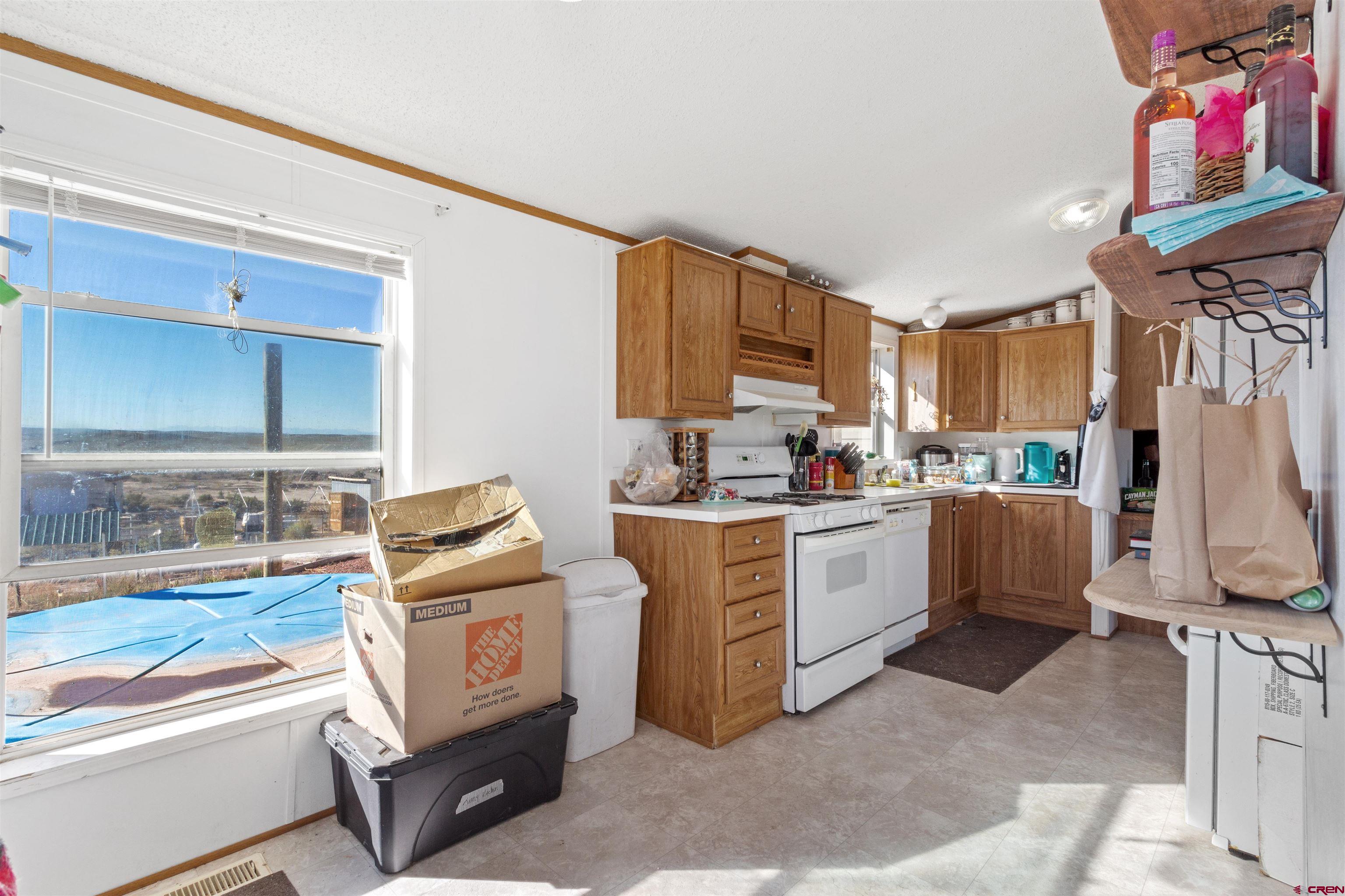 23384 D50 Road Delta, CO 81416 - Photo 11 of 37 a kitchen with white cabinets and black appliances