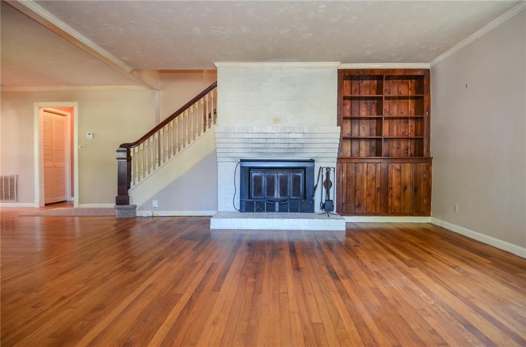 716 Killian Hill Road Southwest Lilburn, GA 30047 - Photo 12 of 56 a view of an empty room with wooden floor fireplace and a window