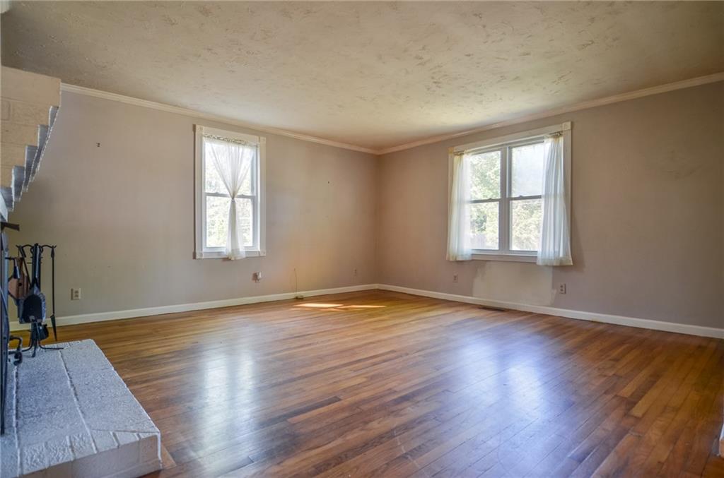 716 Killian Hill Road Southwest Lilburn, GA 30047 - Photo 14 of 56 an empty room with wooden floor and windows