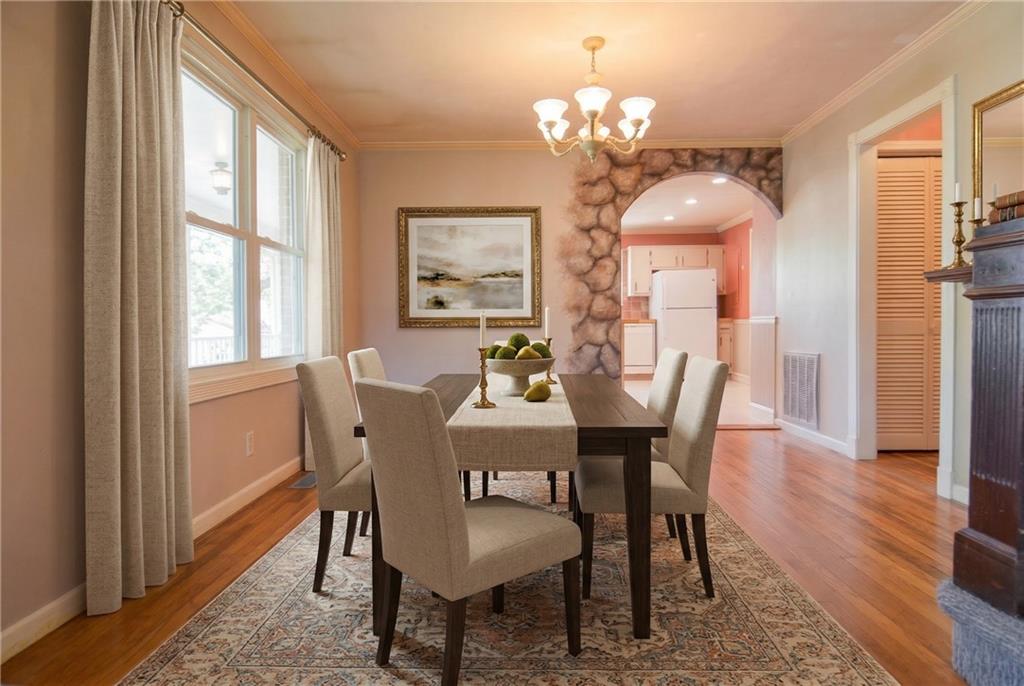 716 Killian Hill Road Southwest Lilburn, GA 30047 - Photo 15 of 56 a view of a dining room with furniture a chandelier and wooden floor