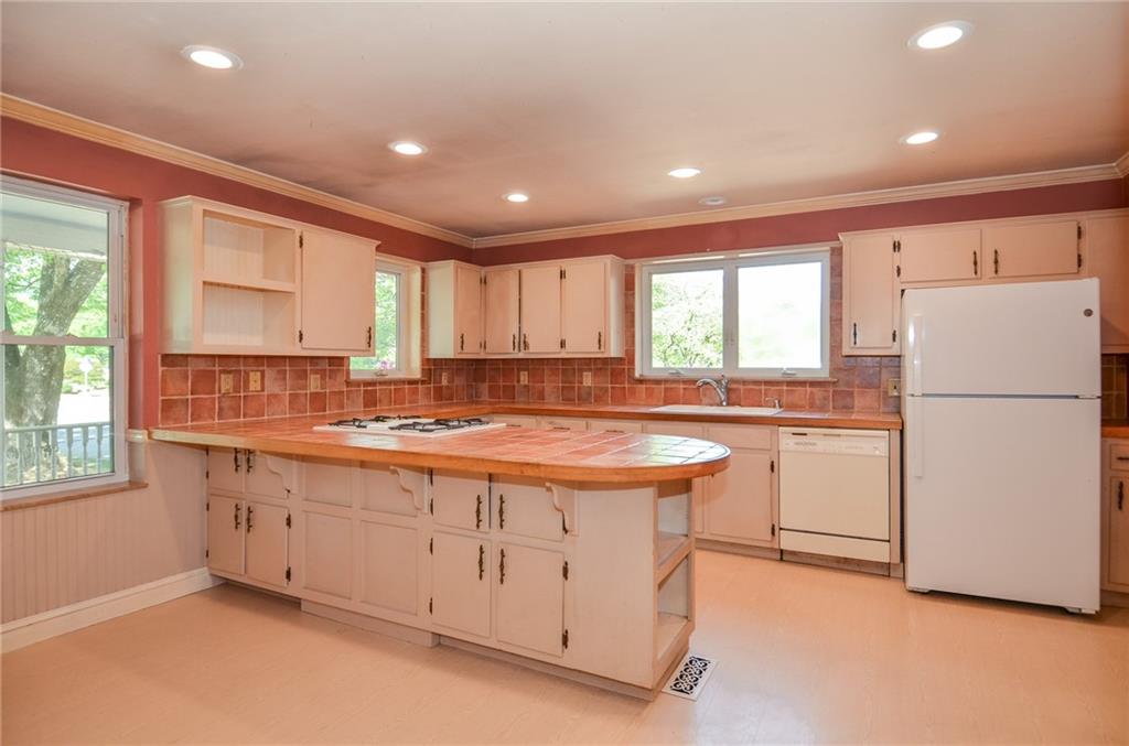 716 Killian Hill Road Southwest Lilburn, GA 30047 - Photo 17 of 56 a kitchen with stainless steel appliances granite countertop a refrigerator a sink dishwasher a stove and white countertops with wooden floor