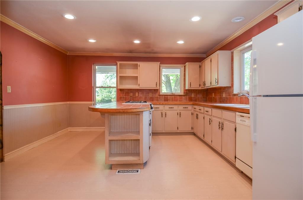 716 Killian Hill Road Southwest Lilburn, GA 30047 - Photo 18 of 56 a kitchen with white cabinets and white appliances
