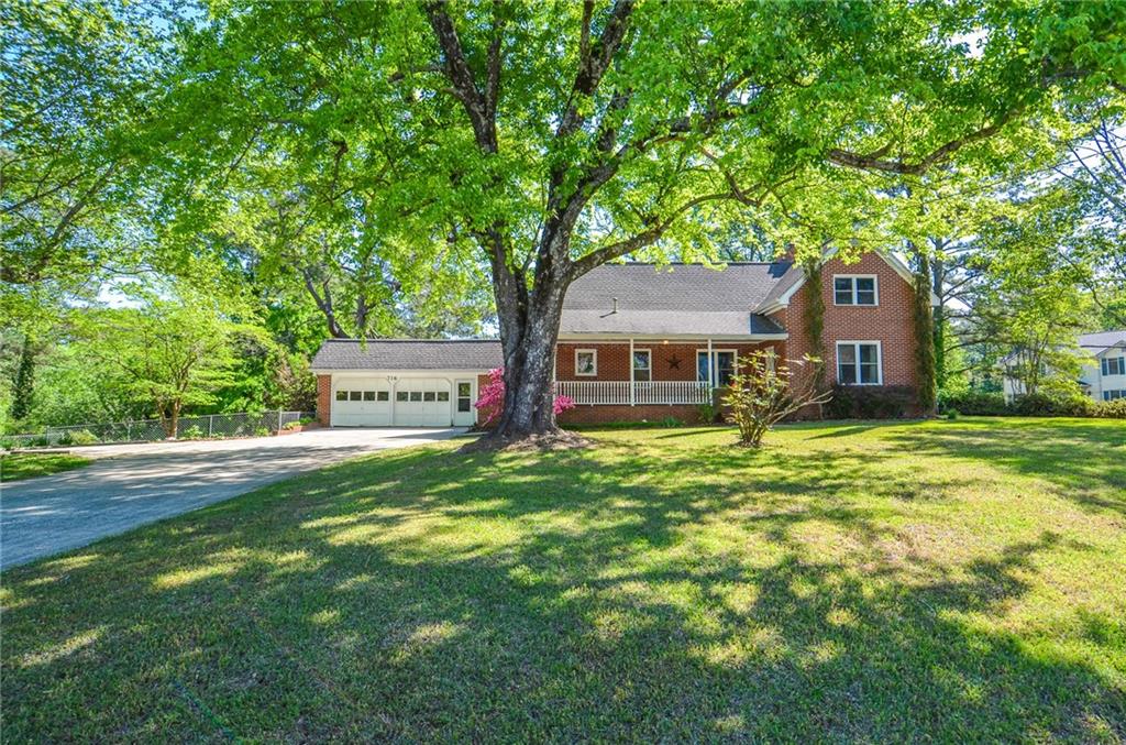 716 Killian Hill Road Southwest Lilburn, GA 30047 - Photo 2 of 56 a front view of a house with a garden