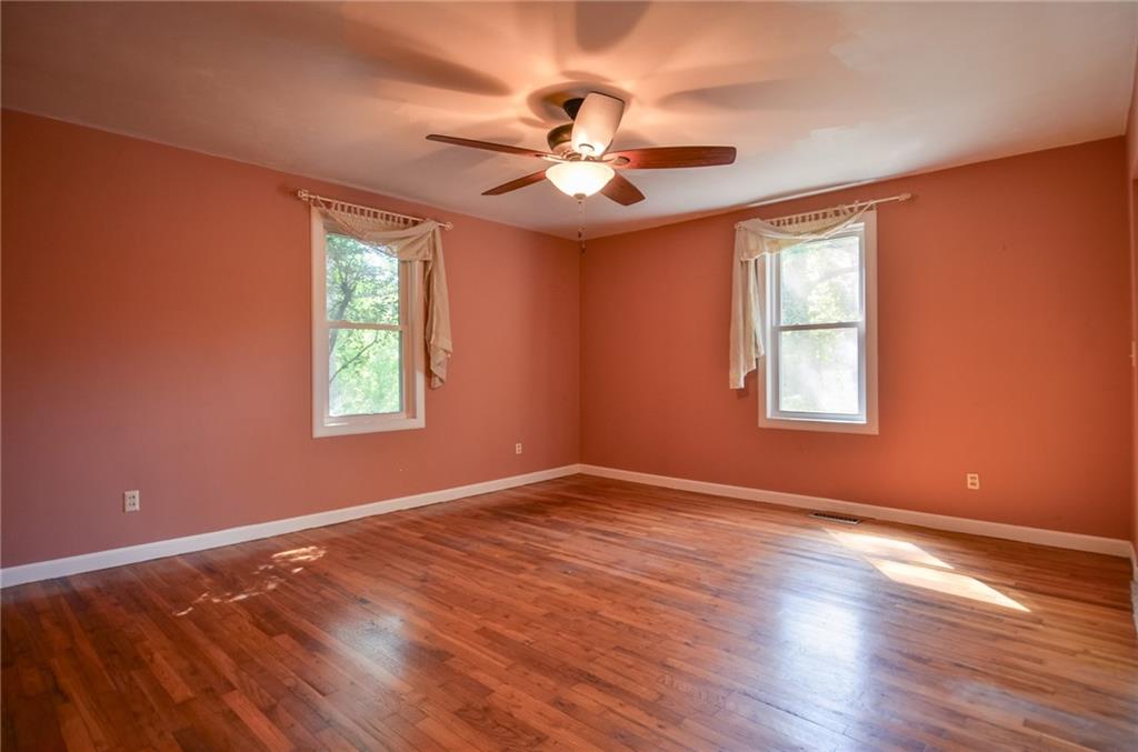 716 Killian Hill Road Southwest Lilburn, GA 30047 - Photo 27 of 56 a view of an empty room with wooden floor and a window