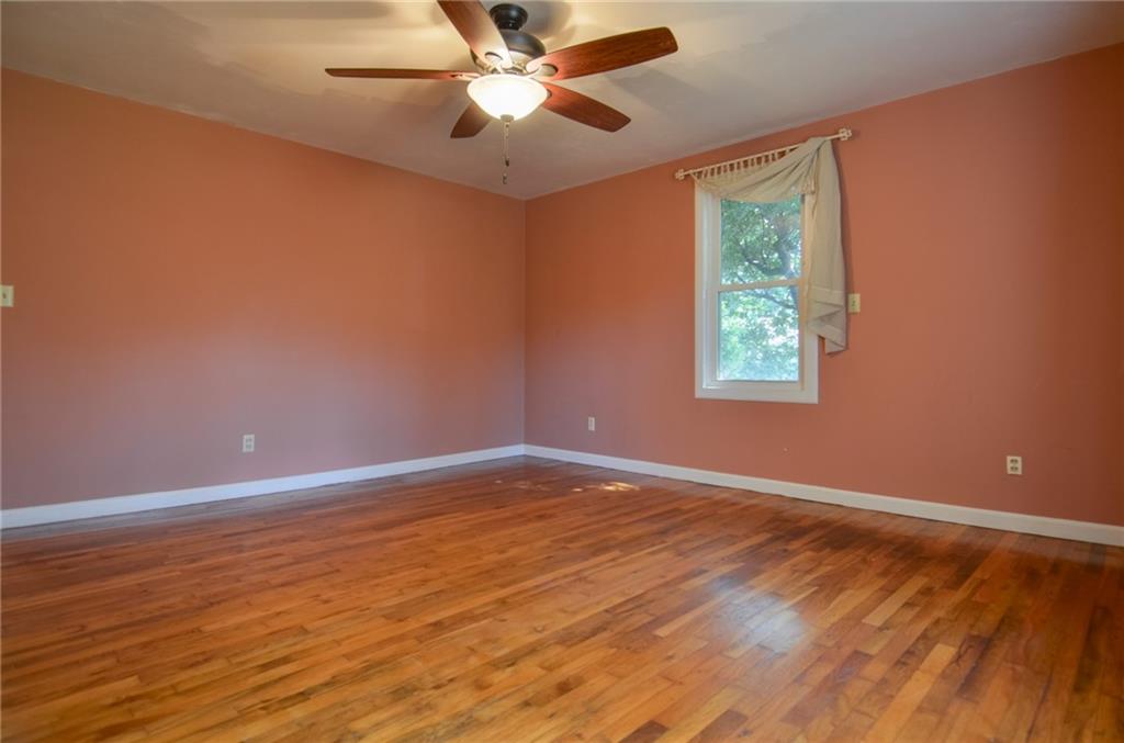 716 Killian Hill Road Southwest Lilburn, GA 30047 - Photo 28 of 56 an empty room with wooden floor fan and windows