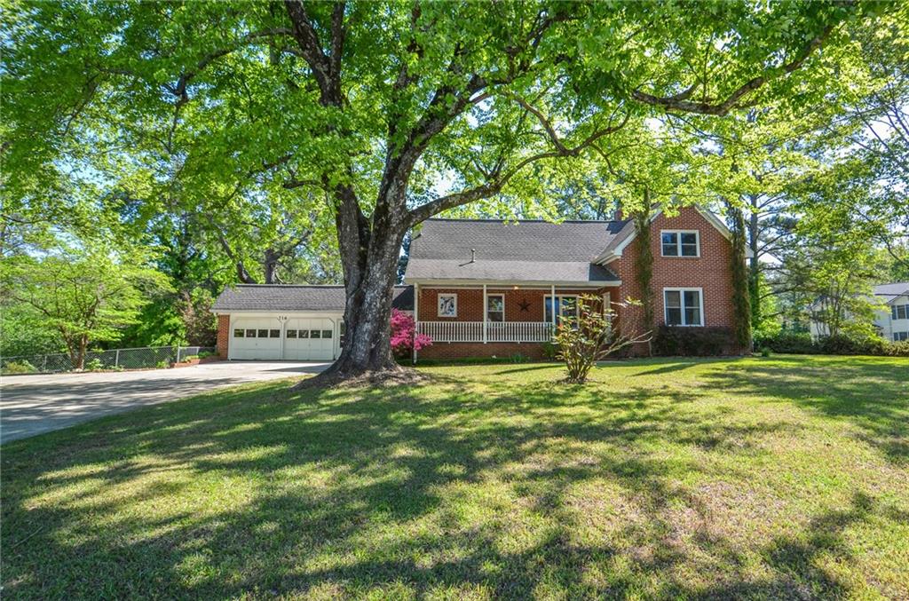 716 Killian Hill Road Southwest Lilburn, GA 30047 - Photo 3 of 56 a front view of a house with a garden