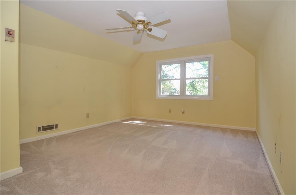 716 Killian Hill Road Southwest Lilburn, GA 30047 - Photo 35 of 56 an empty room with a window and a ceiling fan