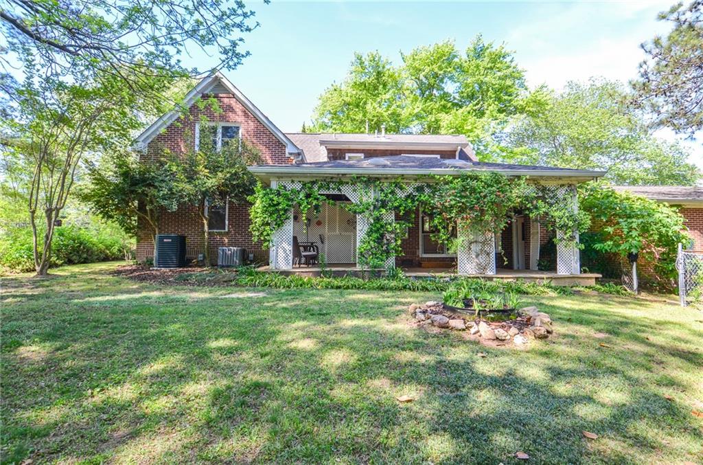 716 Killian Hill Road Southwest Lilburn, GA 30047 - Photo 55 of 56 a view of a backyard with table and chairs and a large tree
