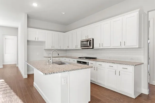 a kitchen with stainless steel appliances granite countertop a sink stove and cabinets