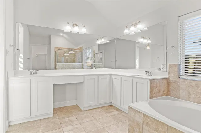a bathroom with a granite countertop sink a mirror and a bathtub