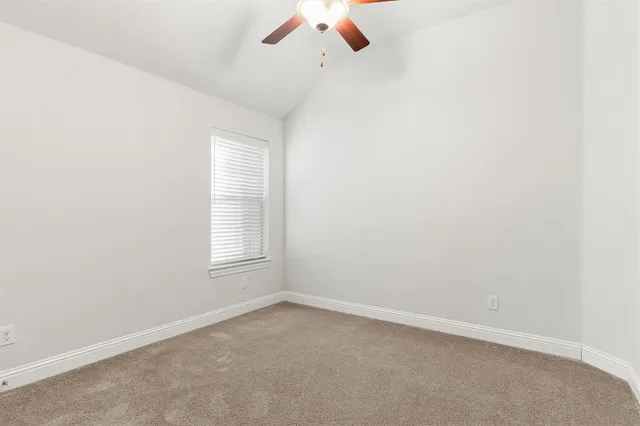 an empty room with chandelier fan