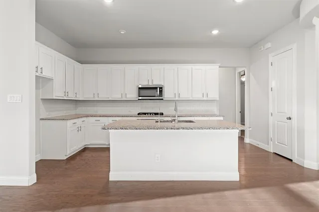 a kitchen with kitchen island sink stove and cabinets