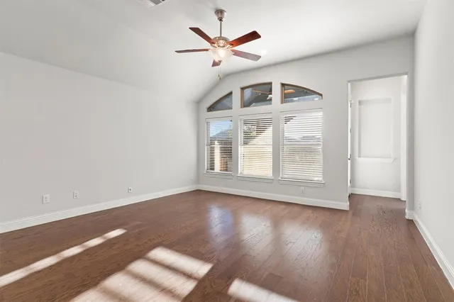 an empty room with fan and windows