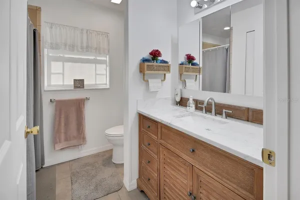 a en suite bathroom with a granite countertop sink toilet and a mirror