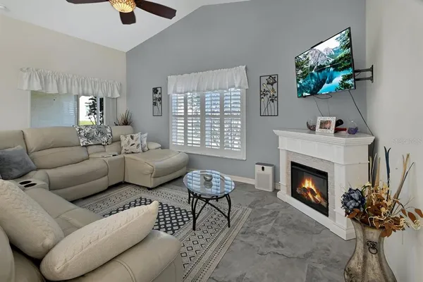 a living room with furniture a fireplace and a flat screen tv