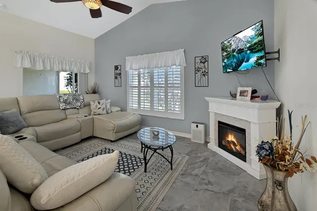 a living room with furniture a fireplace and a flat screen tv