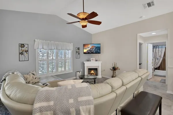 a living room with furniture a fireplace and a window