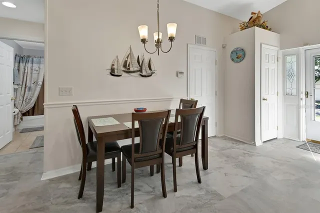 a view of a dining room with furniture and chandelier
