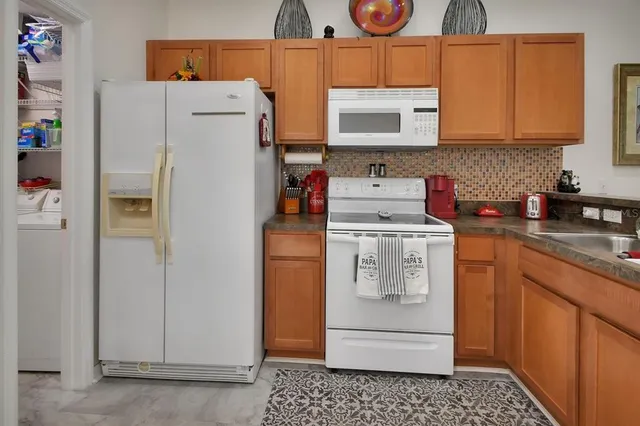 a utility room with refrigerator and washer