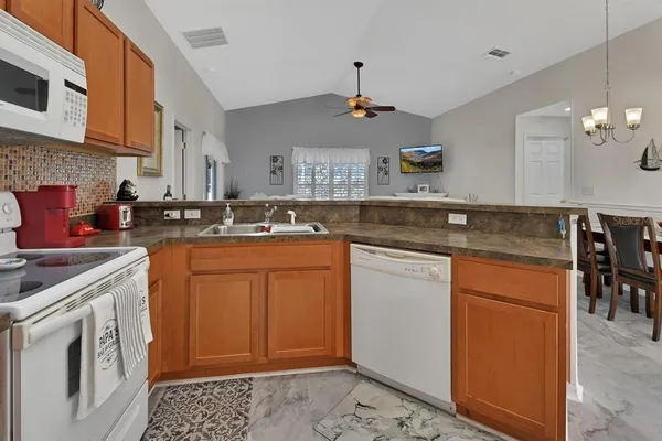 a kitchen with stainless steel appliances granite countertop a sink stove and cabinets