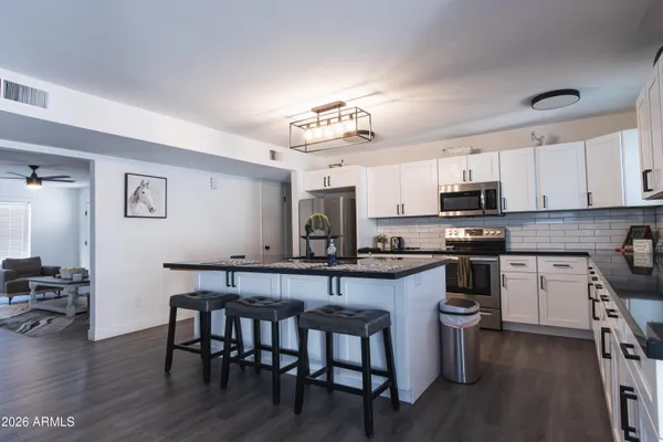 a kitchen with a table chairs microwave and cabinets
