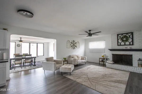 a living room with furniture two window and a fireplace
