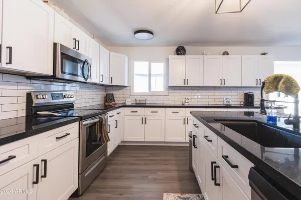 a kitchen with stainless steel appliances granite countertop a sink and stove top oven