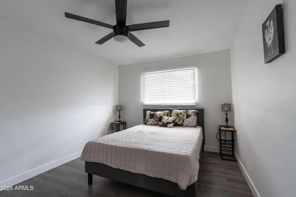 a bedroom with a bed a dresser and a window