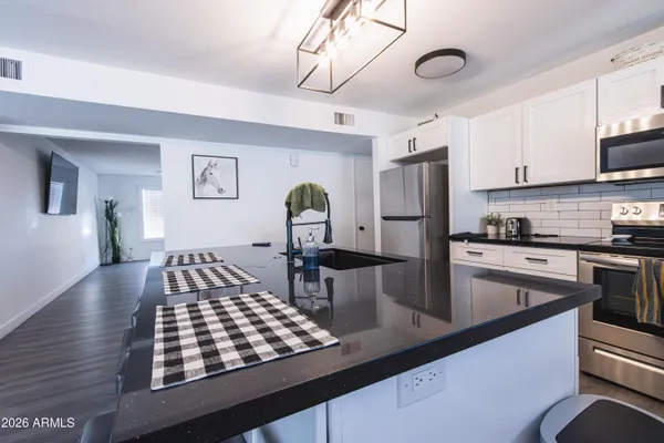 a kitchen with kitchen island a counter space a sink appliances and cabinets