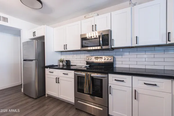 a kitchen with stainless steel appliances granite countertop a stove a refrigerator and a microwave