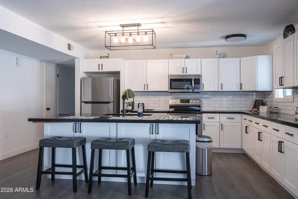 a kitchen with stainless steel appliances a stove a sink a microwave and cabinets