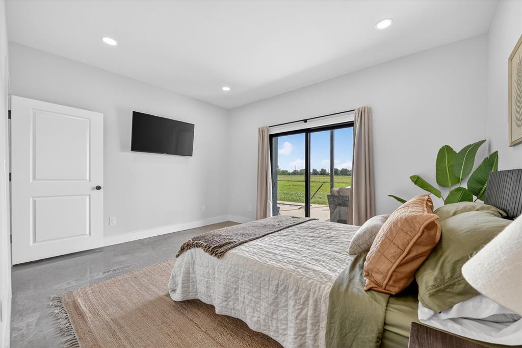 9082 Wolf Run Krum, TX 76249 - Photo 14 of 38 a bedroom with a bed window and a flat screen tv