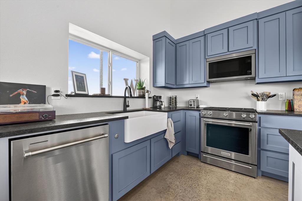 9082 Wolf Run Krum, TX 76249 - Photo 6 of 38 a kitchen with stainless steel appliances granite countertop a sink a stove a microwave and cabinets